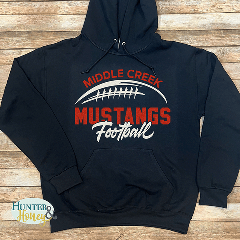 Black hoodie with a 2-color 'Middle Creek Mustangs Football' graphic in red and white glitter.