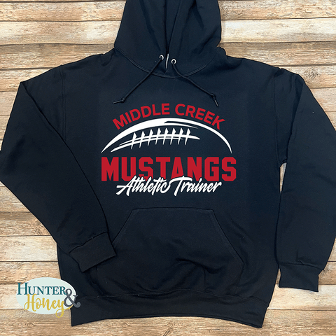 Black hoodie with a two-color 'Middle Creek Mustangs Athletic Trainer' graphic.